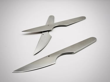 Minimalist stainless steel table knives with sharp blades on a white background 