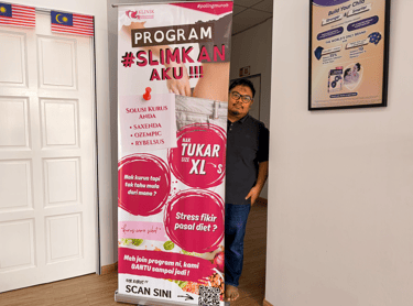 A man stands behind a clinic banner advertising weight loss programs and Ozempic treatments.