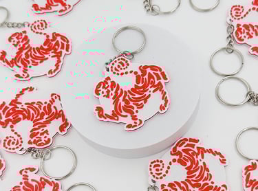Red and white acrylic tiger dojo 3d llaveros posadas  with silver metal rings on a white background.
