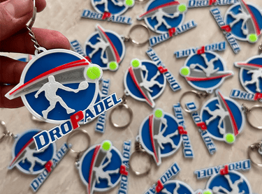  3d llaveros posadas Dropadel featuring a blue circular logo with a padel player silhouette.