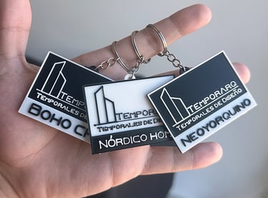 Custom 3D printed keychains for Temporarq architectural design styles held in hand.