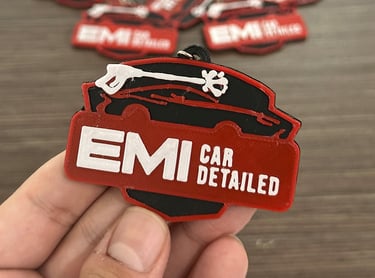  3d llaveros apóstoles EMI Car Detailed held in hand, featuring a pressure washer logo.