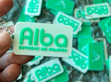 Custom green and white 3D printed  3d llaveros apostoles for Alba Studio de Pilates branding.