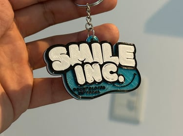 Custom 3D printed Smile Odontologia 3d llaveros posadas in teal and white with graffiti style text.