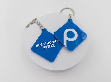 Custom blue 3D printed  3d llaveros posadaswith Electronica Piriz logo on a white display stand.