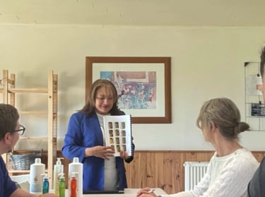 ormation en présentiel : une formatrice présente un support illustré aux participants assis autour