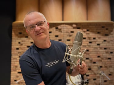 Zdjęcie Sławek Wiesławski w Hertz Studio trzymający Neumann u87 mikrofon pojemnościowy