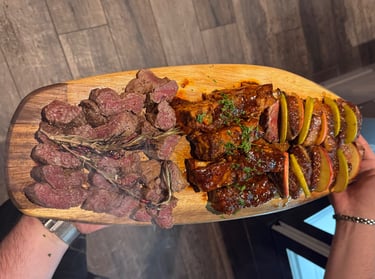 a person holding a large wooden board with steak steak and potatoes