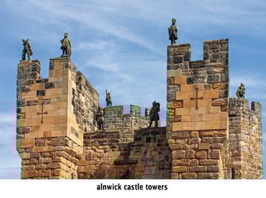 alnwick castle with statues of soldiers on top of a tower