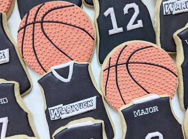Basketball and jersey cookies for a basketball team in black, pink, and orange