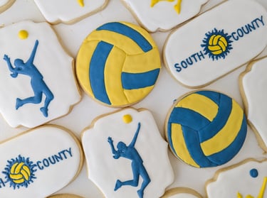 Sugar cookies for South County volleyball designed with volleyballs, girls serving, and team logo