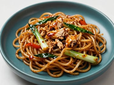 Delectable Javanese stir-fried noodles, Mie Goreng Jawa, glazed with sweet soy sauce, mixed with chicken shreds and vegetables, served on a deep teal ceramic plate under soft studio lighting.