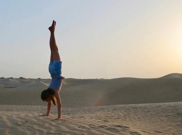 A woman doing a handstand in the desert