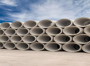 Tubos de concreto circular empilhados para rede de drenagem pluvial.