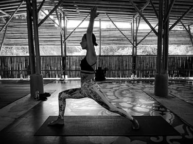A woman in Warrior One pose in Yoga practice at the Bamboo Cottage Langkawi