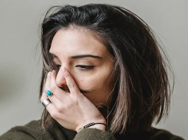 grieving woman with hand over mouth
