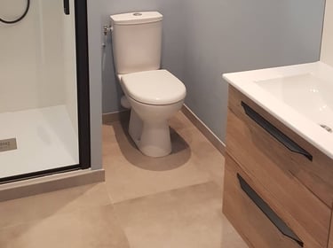 Jolie salle d'eau, avec douche, sol carrelage grand format, meuble et WC