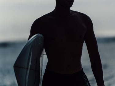 a man holding a surfboard while standing in the water
