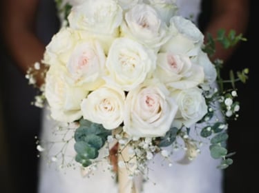 a bride holding a bouquet of white roses; faux florals; event rentals; wedding rentals