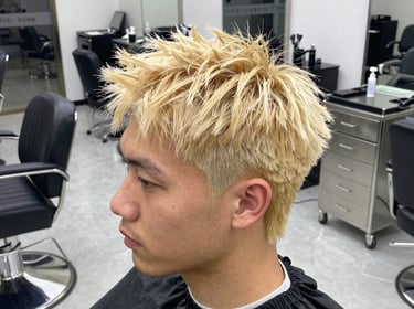 A stylist carefully applying color to a client's hair in a bright, cozy salon space.