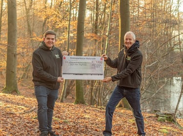 Jörg Grube und Jan Pflugstedt halten einen großen Scheck der KSK Walsrode in den Händen