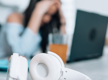 Mulher no trabalho, com as mão no rosto por conta da Ansiedade e preocupação no trabalho