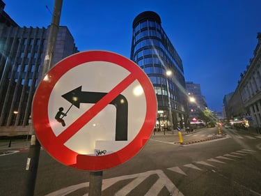 Street art sur panneau de signalisation représentant un garçon sur une balançoire