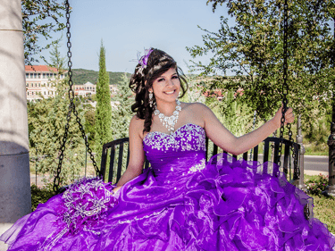 a woman in a purple quinceanera dress sitting on a bench