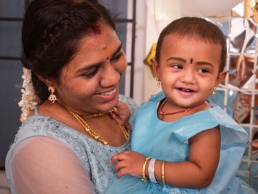 a woman in a blue dress holding a baby