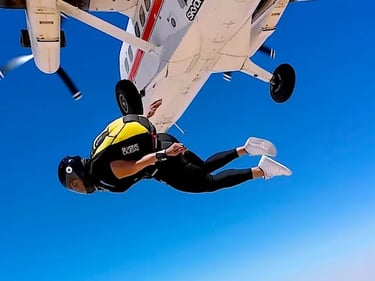 mais alhajri skydiving in yellow and black jumpsuit after jumping from a plane