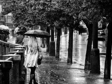 Photo d'une jeune femme femme blonde de dos qui marche sous la pluie a Pregue
