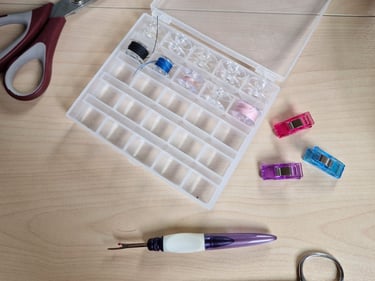 sewing equipment: scissors, clips, threads... placed on a wooden table
