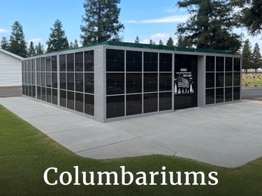 A modern outdoor granite columbarium for cremated remains in a peaceful cemetery setting.