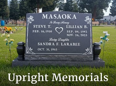 A custom grey granite upright memorial headstone for the Masaoka family in a green cemetery lawn.