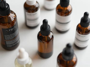 Close-up overhead shot of cosmetic product bottles and packaging arranged on a clean white surface under bright studio lighting, no people