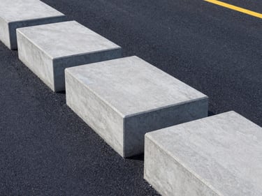 Close-up of concrete curbstones lining a modern asphalt road, sharp edges, clean perspective, architectural lighting