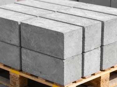 Macro shot of high-quality grey cement blocks stacked neatly on a wooden pallet, sharp concrete texture, bright daylight