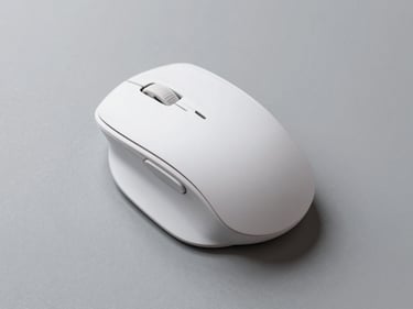 Overhead flat-lay of a wireless ergonomic mouse on a neutral grey surface, studio strobe lighting, side buttons and USB receiver detail visible, clean minimal shadow