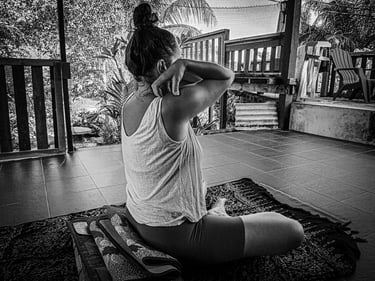 A woman practises a shoulder rotation exercise as part of the Pawanmukhtasan series