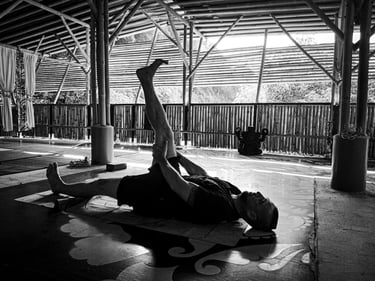 A man practices a yoga pose at Bamboo Cottage, Langkawi