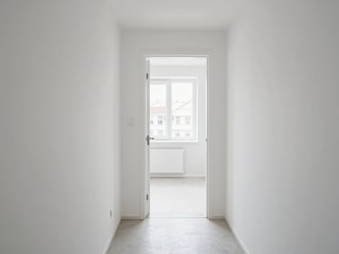 Interior of a compact Klaipėda apartment, clean white walls, entry hallway leading to a bright room, natural daylight from a north-facing window, no furniture clutter, functional and tidy