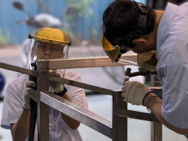 永技企業工程師團隊在工廠內焊接不鏽鋼框架,專注於精密製作與設計。