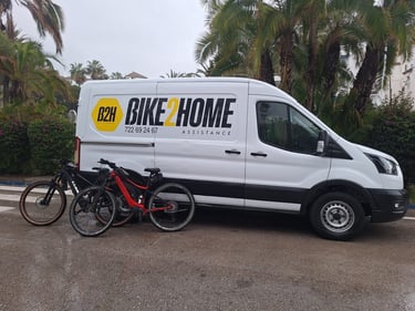 Bike2Home assistance van parked next to several mountain bikes in Marbella