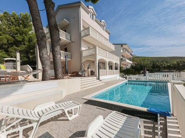 The photo shows a house with a part of the yard with a west sun terrace and a swimming pool.