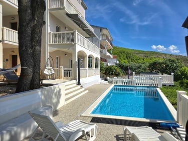 The photo depicts the house and yard with the pool as seen from the western sunny terrace.