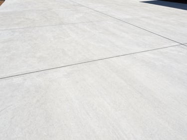 Clean concrete driveway, sharp lines, bright daylight, professional editorial style.
