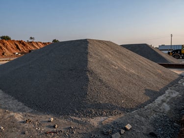 Coarse sub-base material laid out on an infrastructure site, twilight lighting