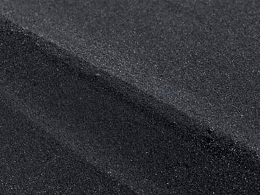 Coarse dark industrial black sand, high contrast lighting, sharp focus