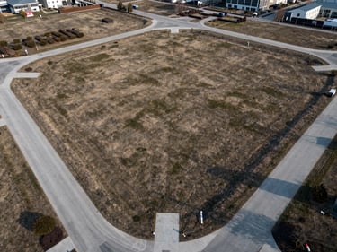 Aerial drone perspective of a clean, structured land lot development with visible road layouts.
