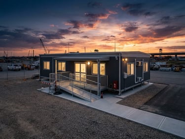 Double-wide relocatable site office structure deployed on a clean industrial site, sunset sky, architectural photography.